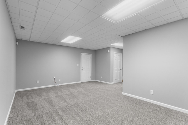 empty room featuring carpet flooring and a paneled ceiling