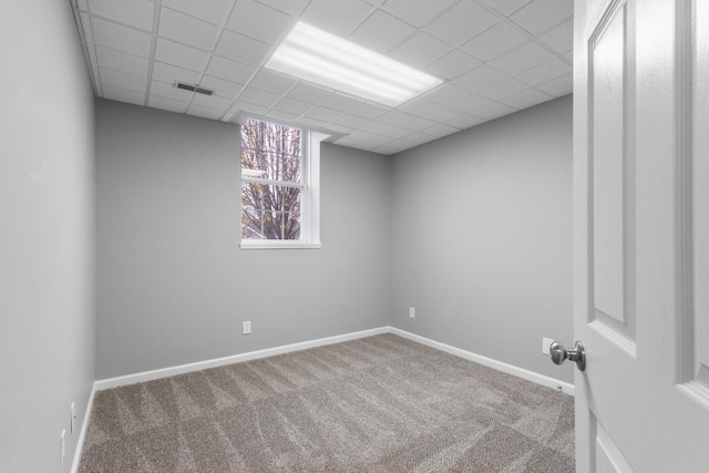 spare room with carpet flooring and a paneled ceiling