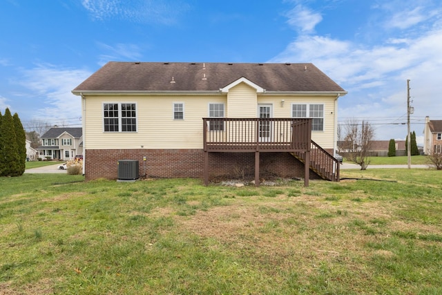 rear view of house featuring a lawn, cooling unit, and a deck