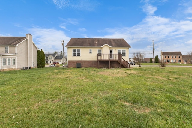 back of property featuring central AC, a deck, and a lawn