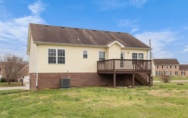 rear view of property featuring central AC unit, a deck, and a yard