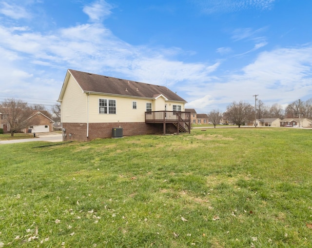 rear view of house featuring a lawn, a wooden deck, and central AC