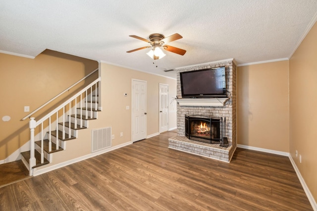 unfurnished living room with a fireplace, ceiling fan, hardwood / wood-style floors, and a textured ceiling