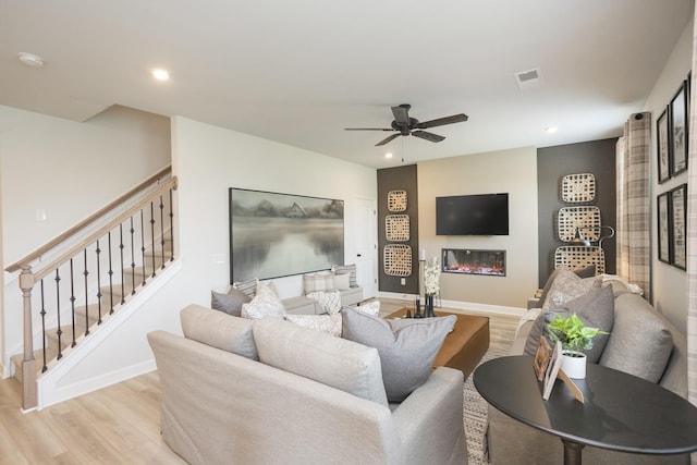 living room featuring ceiling fan and light hardwood / wood-style floors