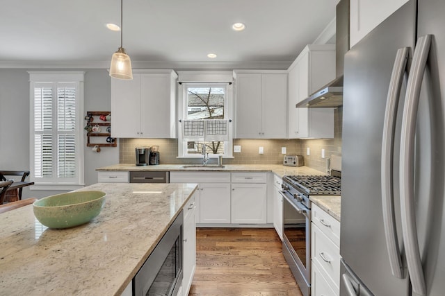 kitchen featuring white cabinetry, light stone counters, light hardwood / wood-style flooring, decorative light fixtures, and appliances with stainless steel finishes