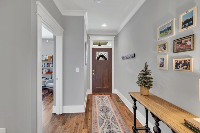 foyer entrance featuring crown molding and dark hardwood / wood-style flooring