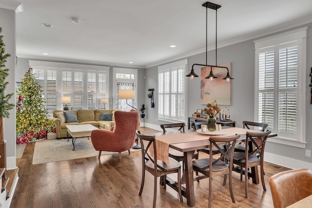 dining room featuring hardwood / wood-style flooring and crown molding