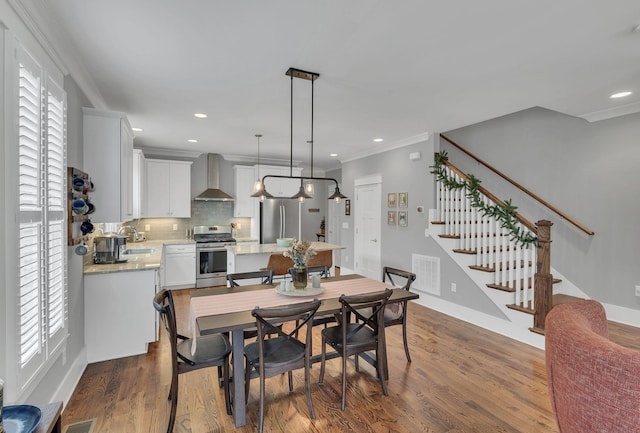 dining room featuring plenty of natural light, dark hardwood / wood-style floors, sink, and crown molding