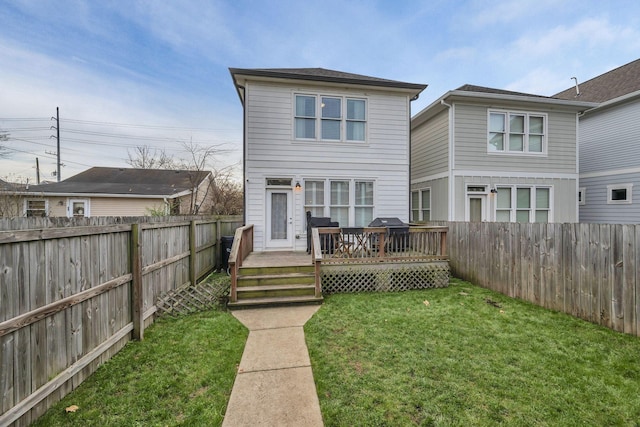 rear view of house featuring a yard and a deck