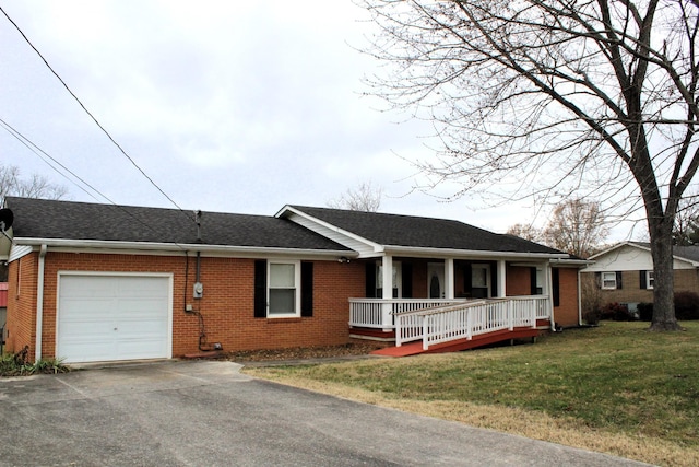 single story home featuring a front lawn, covered porch, and a garage