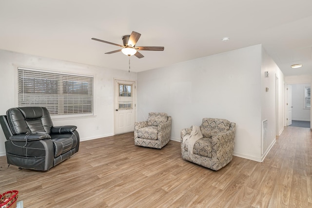 sitting room with ceiling fan and light wood-type flooring