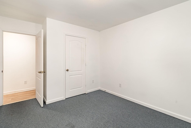 unfurnished bedroom with dark carpet