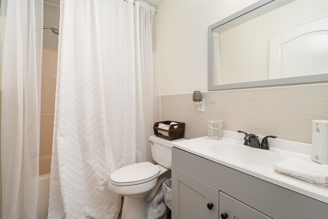 full bathroom featuring vanity, toilet, tile walls, and shower / bath combo with shower curtain