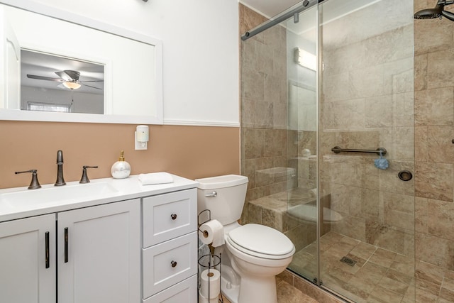 bathroom with vanity, toilet, a shower with door, and ceiling fan