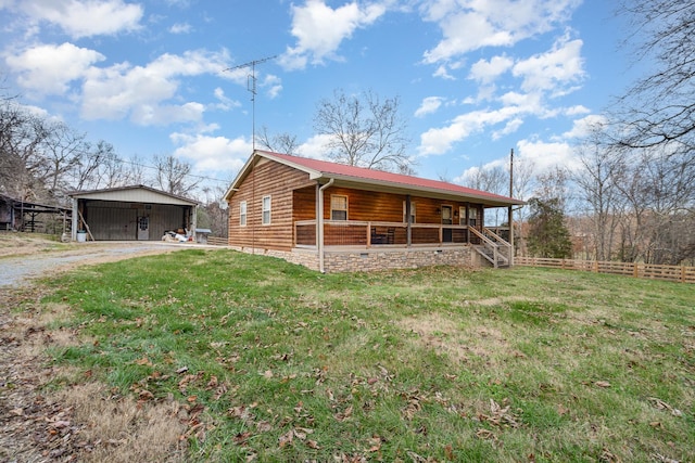 log-style house with an outbuilding, a porch, and a front lawn