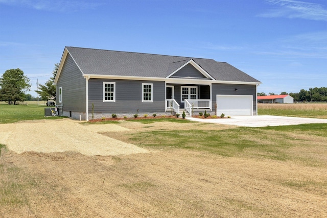 view of front of property featuring a front lawn, a garage, and a porch