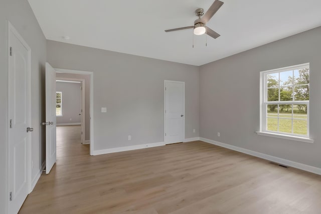 unfurnished bedroom featuring ceiling fan, light hardwood / wood-style floors, and multiple windows