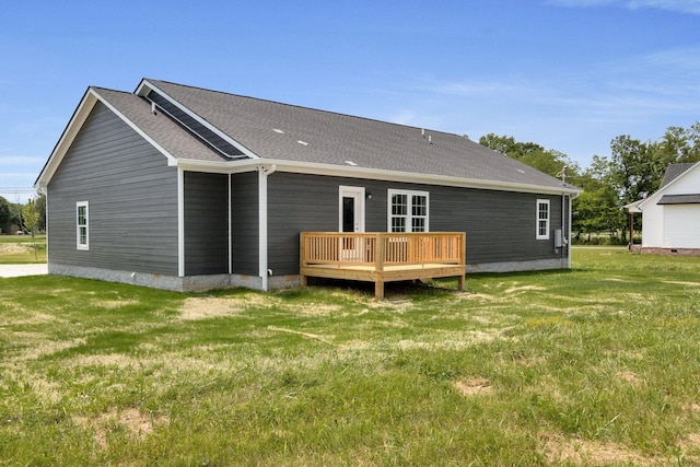 rear view of house featuring a deck and a yard