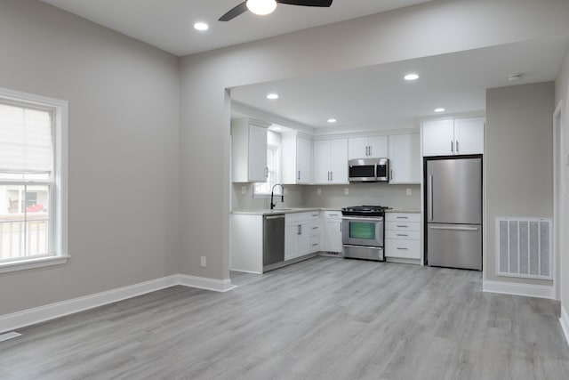 kitchen featuring ceiling fan, white cabinets, light hardwood / wood-style floors, and appliances with stainless steel finishes