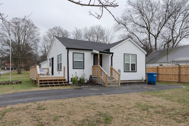 view of front facade with a wooden deck and a front yard