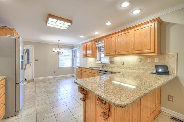 kitchen with kitchen peninsula, light stone counters, a notable chandelier, and appliances with stainless steel finishes