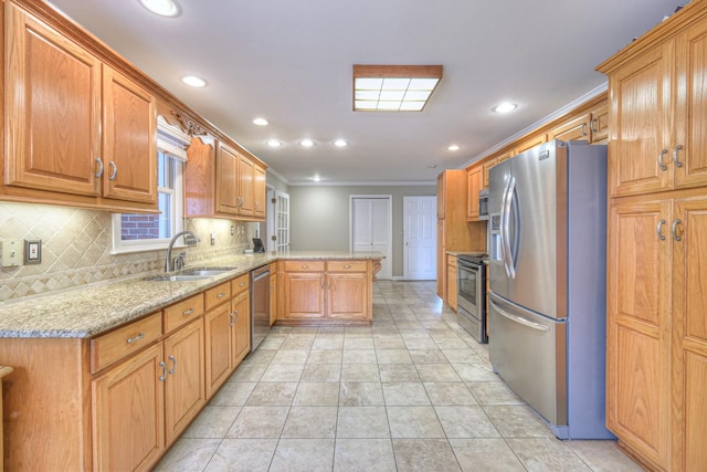 kitchen with backsplash, sink, appliances with stainless steel finishes, light stone counters, and kitchen peninsula