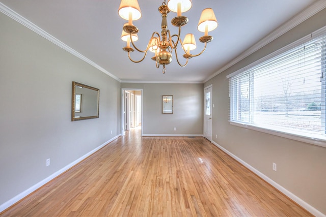 empty room featuring ornamental molding, a notable chandelier, and light wood-type flooring