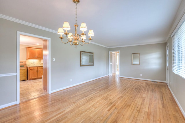 unfurnished room featuring an inviting chandelier, crown molding, and light hardwood / wood-style flooring