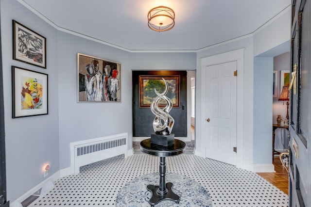 foyer with crown molding, radiator heating unit, and light parquet floors