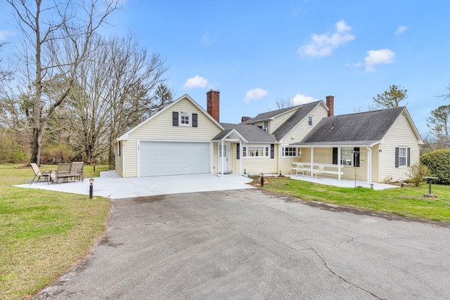 view of front of house featuring a front yard, a porch, and a garage