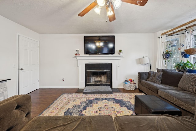 living room featuring a textured ceiling, ceiling fan, and dark hardwood / wood-style flooring