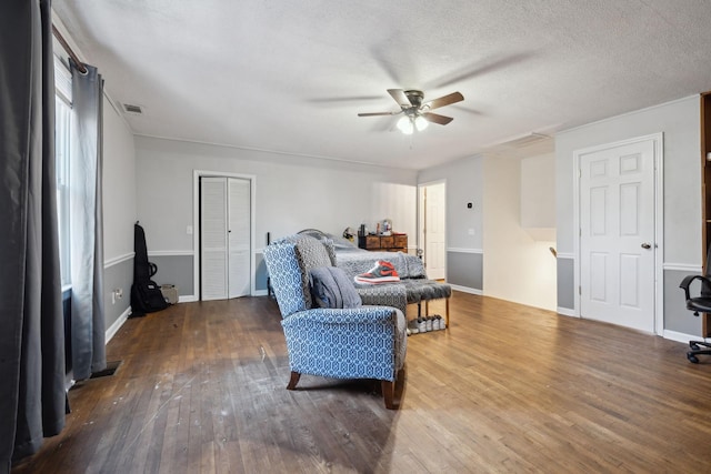 living room featuring ceiling fan, a textured ceiling, and wood-type flooring