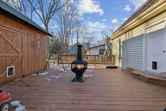 wooden terrace featuring an outdoor fire pit