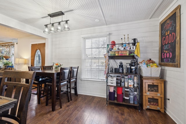 dining area with wooden walls and dark hardwood / wood-style floors