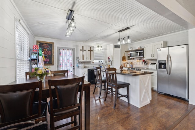 kitchen featuring appliances with stainless steel finishes, white cabinets, decorative backsplash, and plenty of natural light