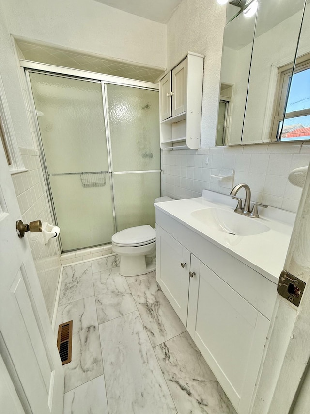 bathroom with backsplash, an enclosed shower, vanity, tile walls, and toilet