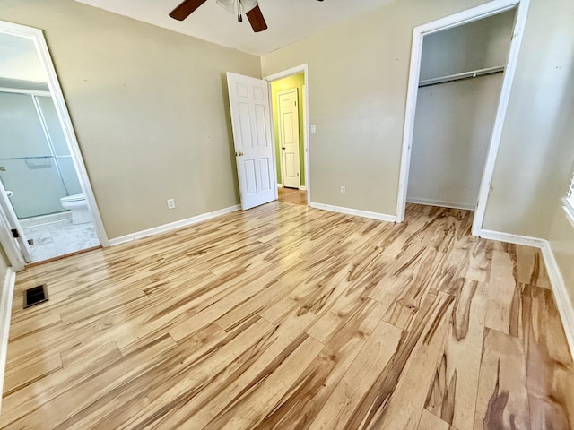 unfurnished bedroom with a closet, connected bathroom, light hardwood / wood-style floors, and ceiling fan