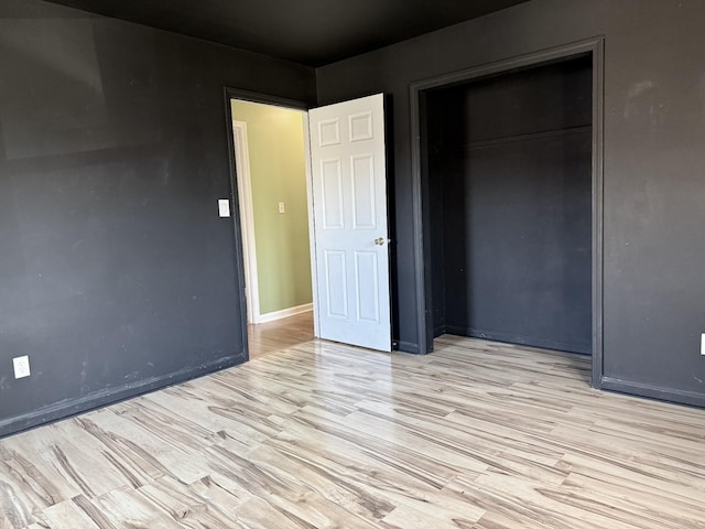 unfurnished bedroom with a closet and light hardwood / wood-style floors