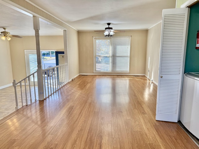 empty room with light hardwood / wood-style floors, washer / clothes dryer, ceiling fan, and ornamental molding