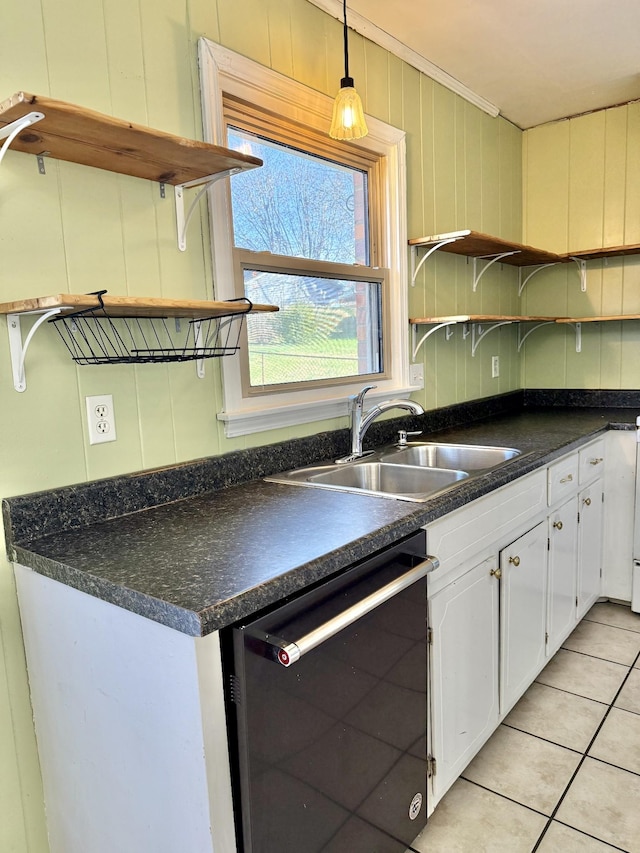 kitchen with sink, white cabinets, stainless steel dishwasher, and light tile patterned floors