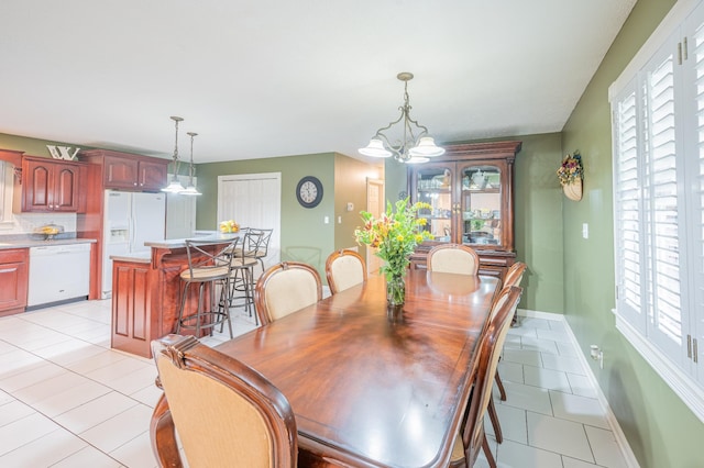 tiled dining area with a chandelier