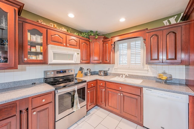 kitchen with white appliances, sink, light tile patterned floors, and tasteful backsplash