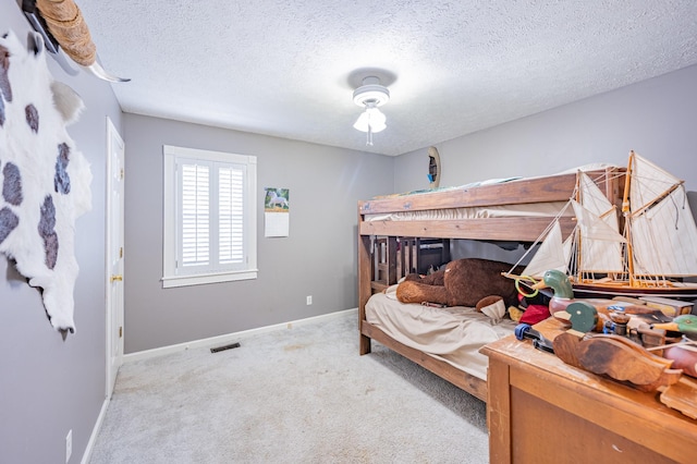 bedroom with light colored carpet and a textured ceiling