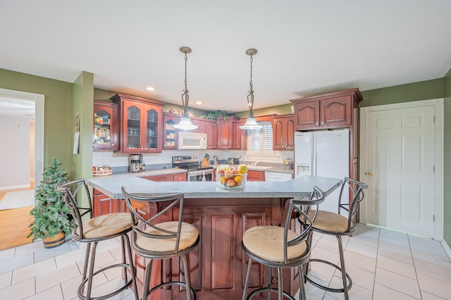 kitchen featuring sink, backsplash, decorative light fixtures, white appliances, and light tile patterned floors