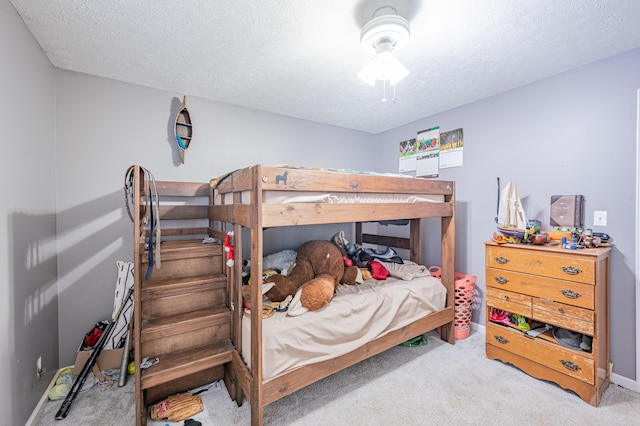 bedroom with carpet, ceiling fan, and a textured ceiling