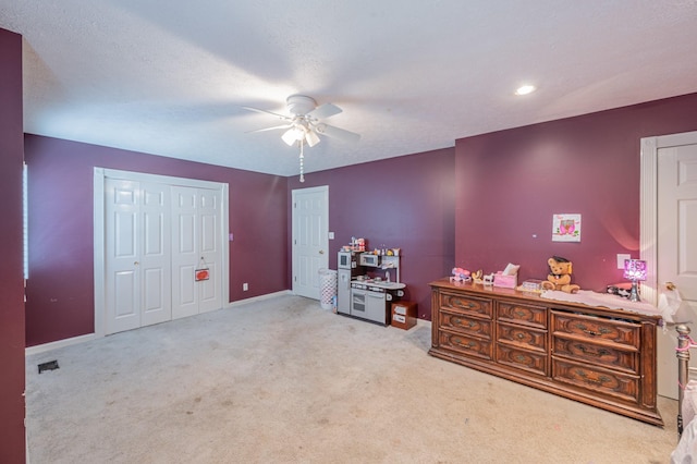 bedroom with light carpet, a textured ceiling, and ceiling fan