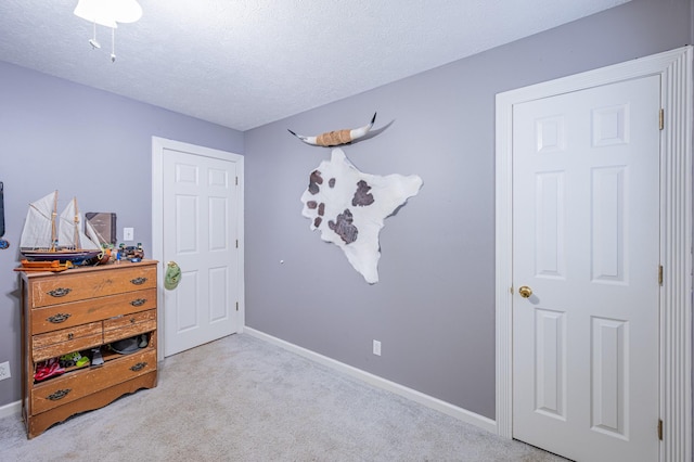 bedroom featuring light carpet and a textured ceiling