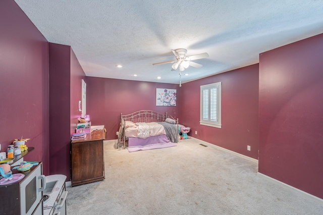 carpeted bedroom featuring a textured ceiling and ceiling fan