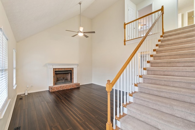 unfurnished living room with a fireplace, hardwood / wood-style flooring, high vaulted ceiling, and a healthy amount of sunlight