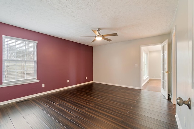 unfurnished room with dark hardwood / wood-style floors, ceiling fan, and a textured ceiling